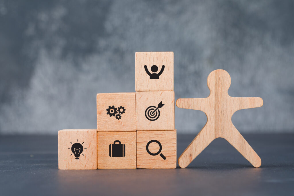 Conceptual of success and target. with wooden human and blocks on dark color background side view. horizontal image